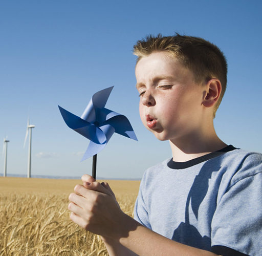 Boy holding pinwheel on wind farm